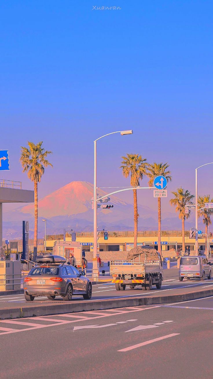 a road with traffic during sunset with mount fuji in the background